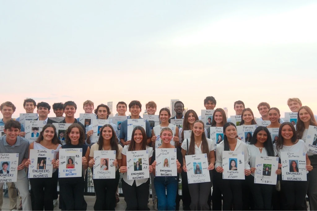 New EiB recruits holding their handmade introduction posters on a rooftop